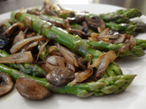 A close up of asparagus, mushrooms and shallots