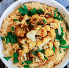 Bowl of cauli hummus and roasted florets with parsley