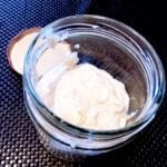 open glass jar with no egg mayo and lid in the background