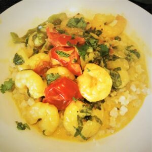 prawn curry with tomatoes and spinach and a vibrant yellow sauce