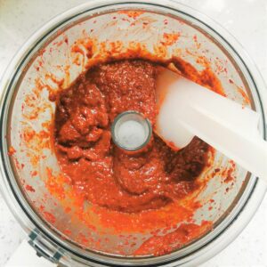 aerial view of belner bowl with red Gochugaru paste and a white spatula