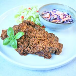 keto fried chicken on a white plate with a small bowl of coleslaw and salad