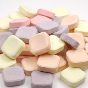 a pile of pastel coloured indigestion relief tablets