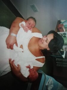 Natasha holding the twins in hospital.